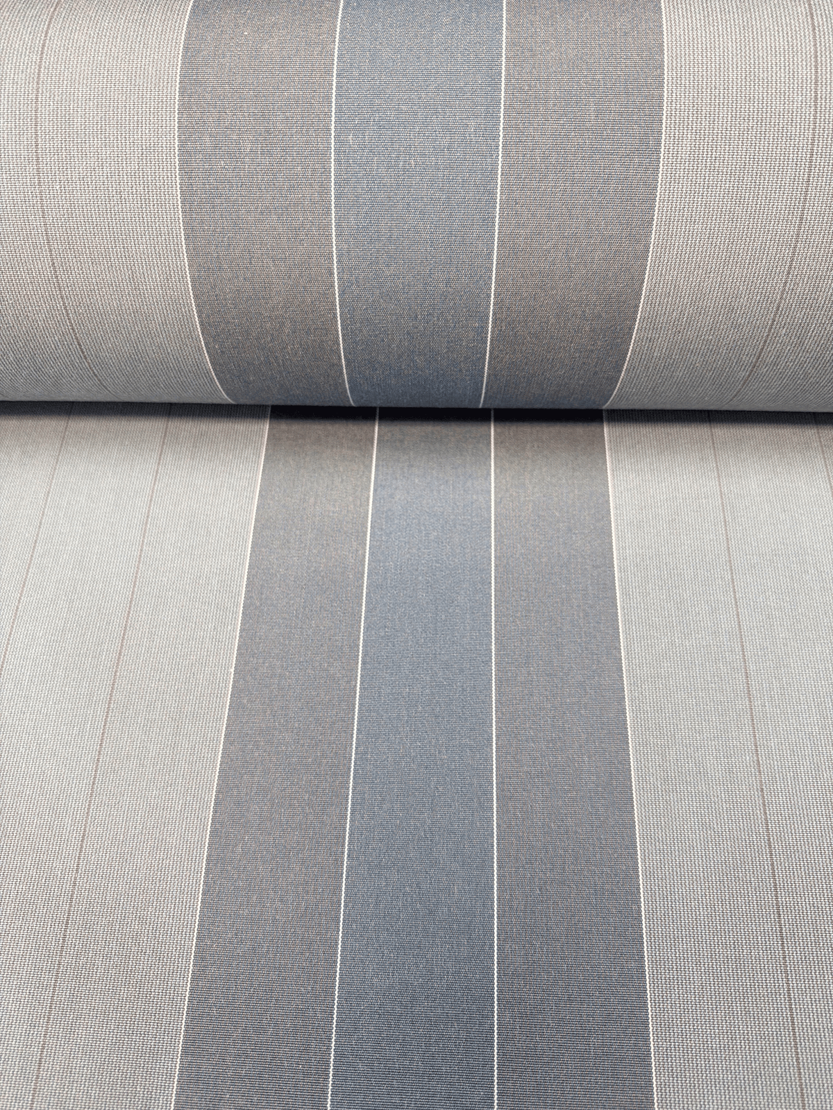 A close-up of striped dickson canvas with alternating vertical bands of light gray, medium gray, and charcoal blue, featuring a subtle textured weave.